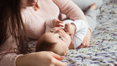 A Mother and baby child on a bed.